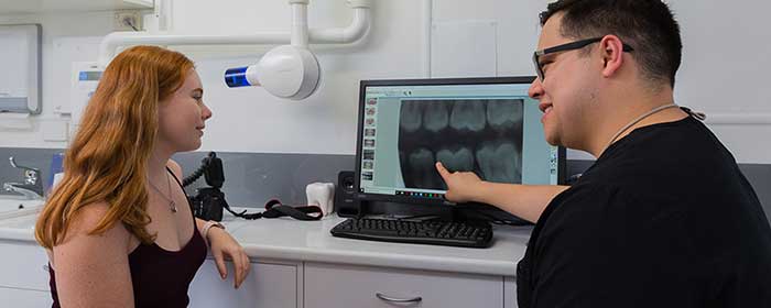 Dr Julian Dantes Mooloolaba dentist showing patient xrays at Fenton Dental